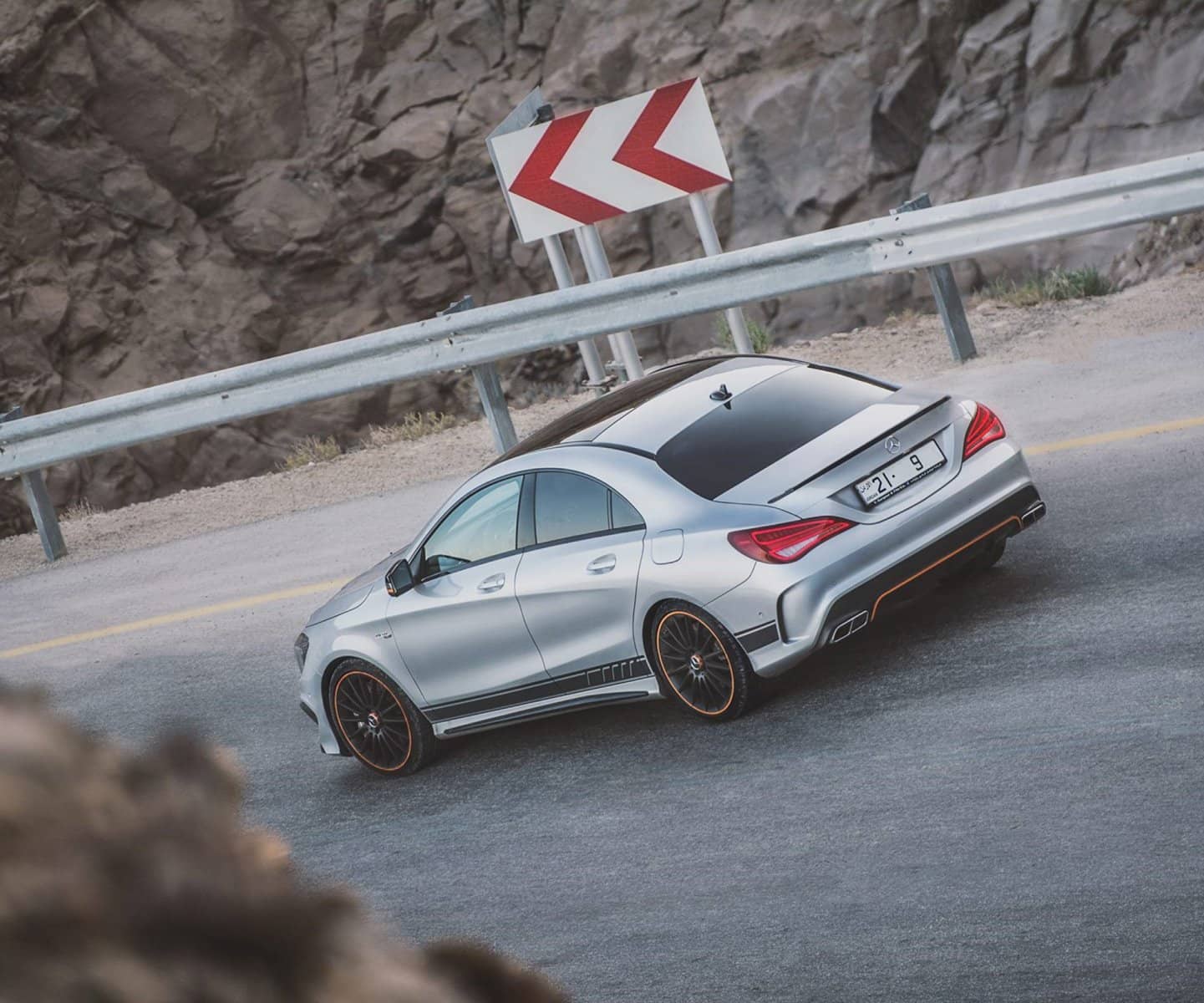 Silver Mercedes cornering on a mountain road