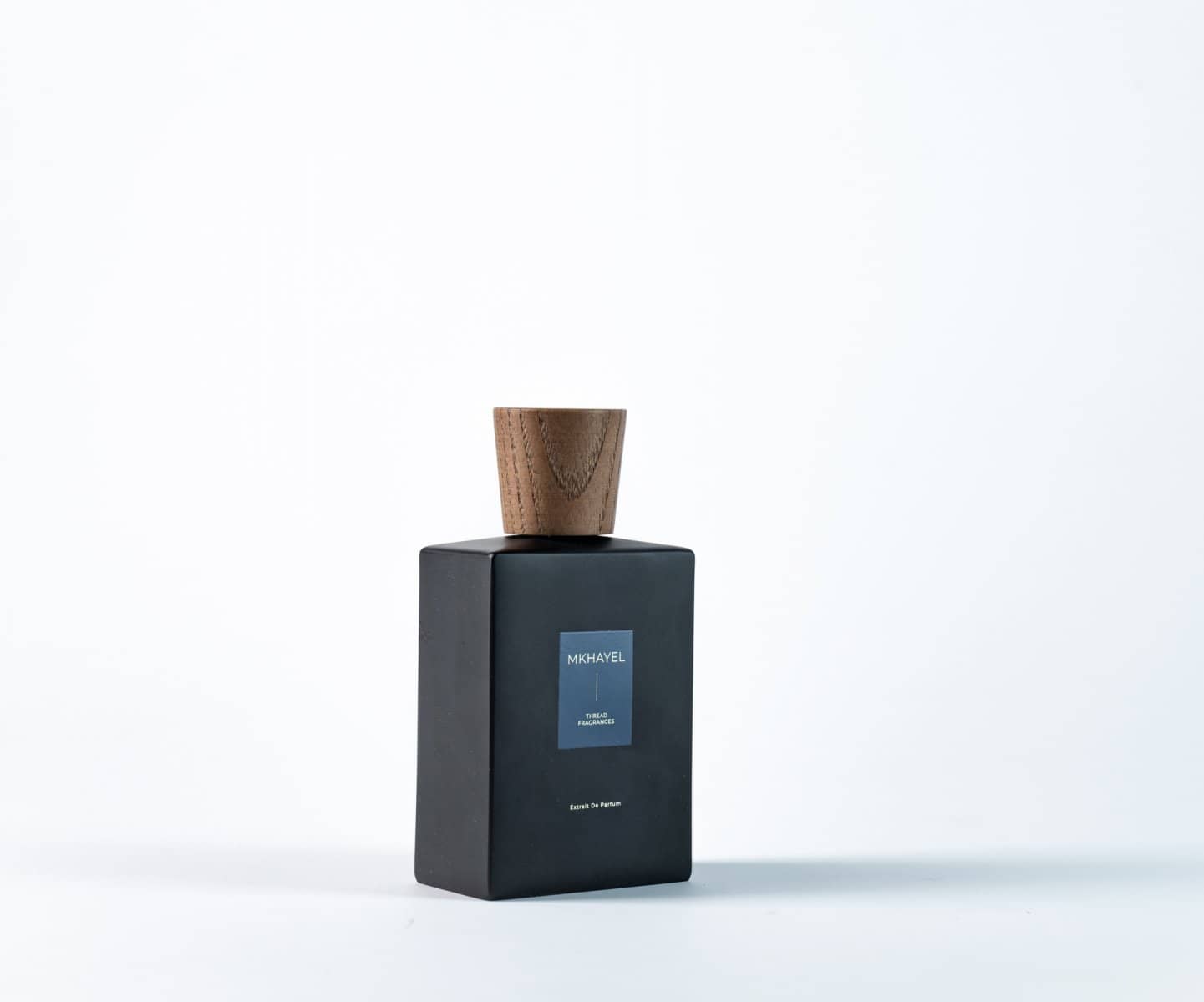 Pale perfume bottle and carton on white
