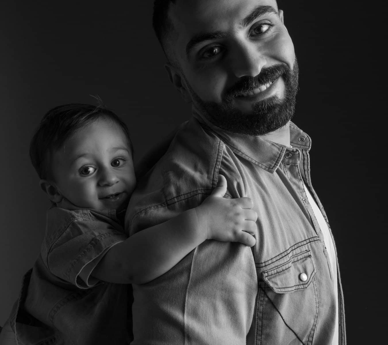 Black-and-white portrait of a father holding his son