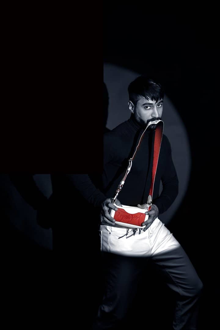 Low-key portrait of a man holding a white bag