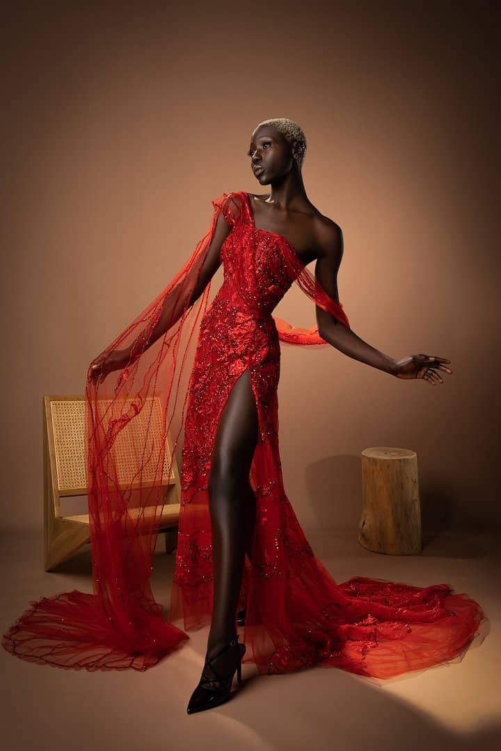 Model in a sheer red gown mid-stride