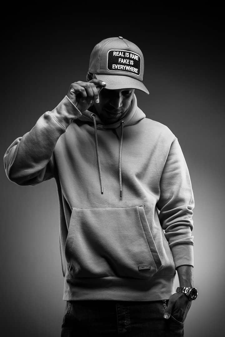 Monochrome portrait of a man in a cap and hoodie