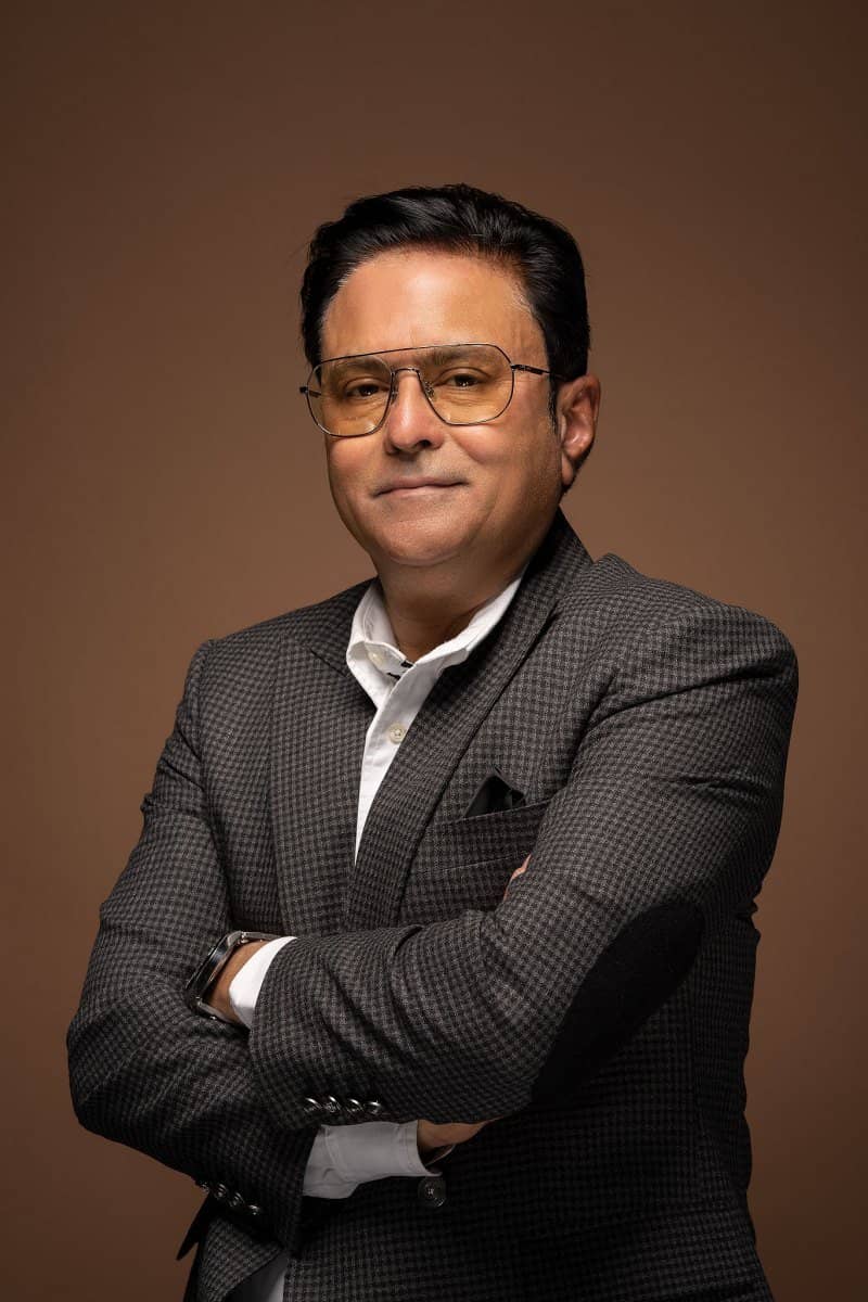 Man in glasses and a tweed jacket on a warm backdrop