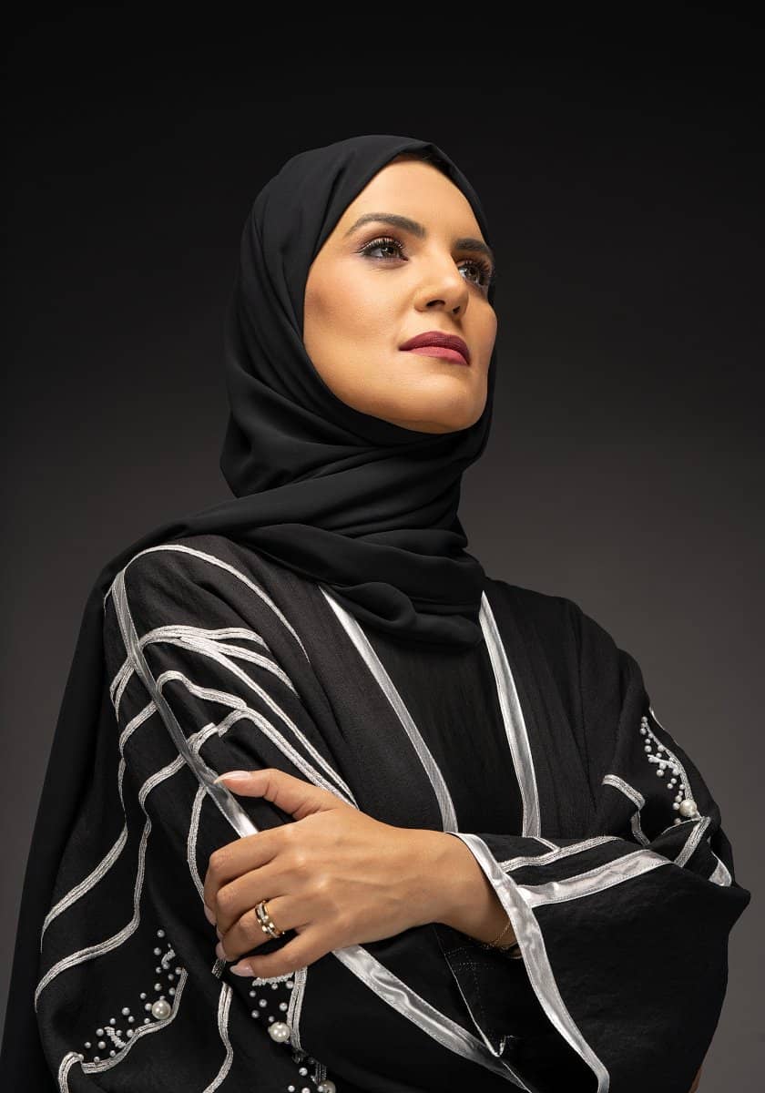 Woman in a black abaya with white trim