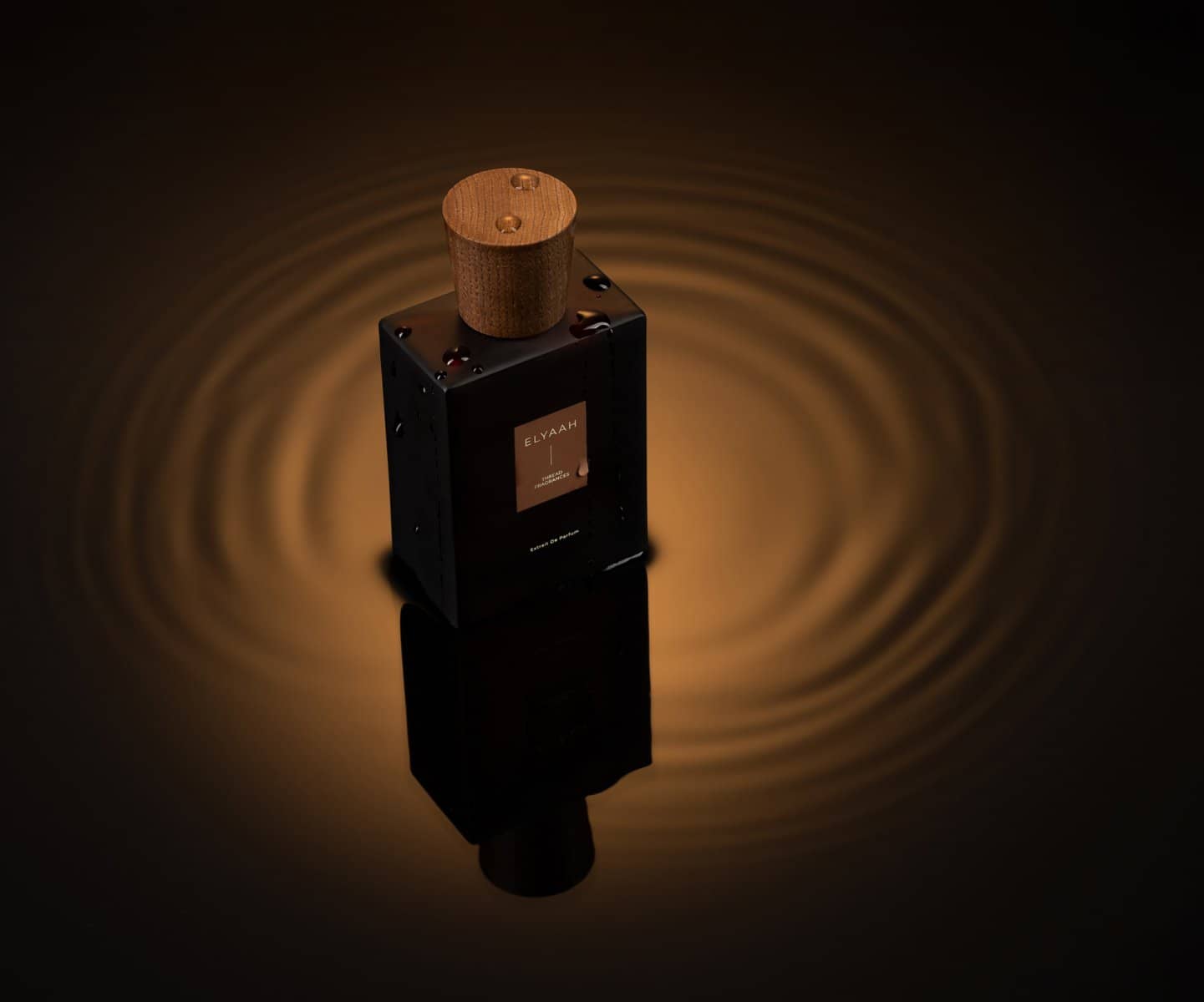 Olive perfume bottle rising from a black plinth