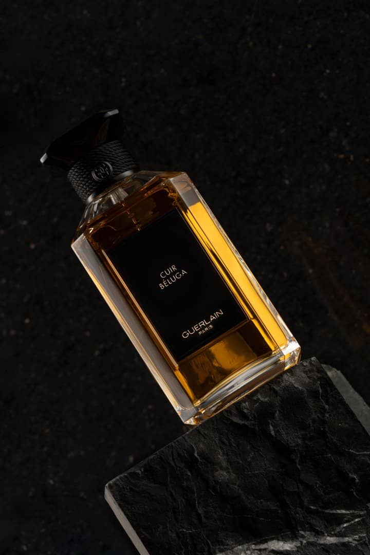 Green perfume bottle reflected in rippled water
