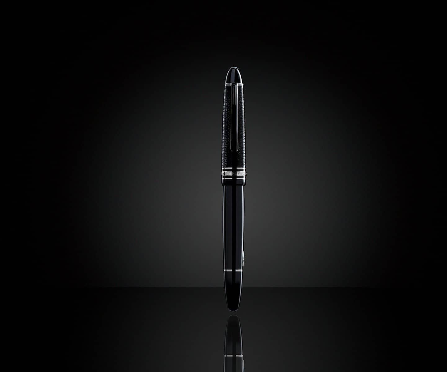 Black fountain pen standing on a glossy surface