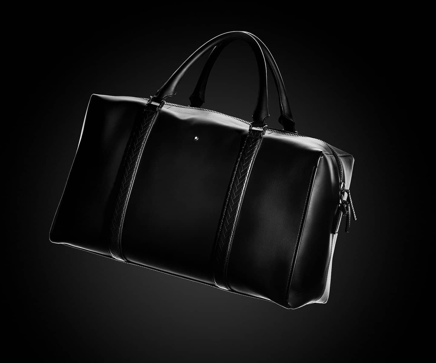 Black leather holdall in low-key studio light