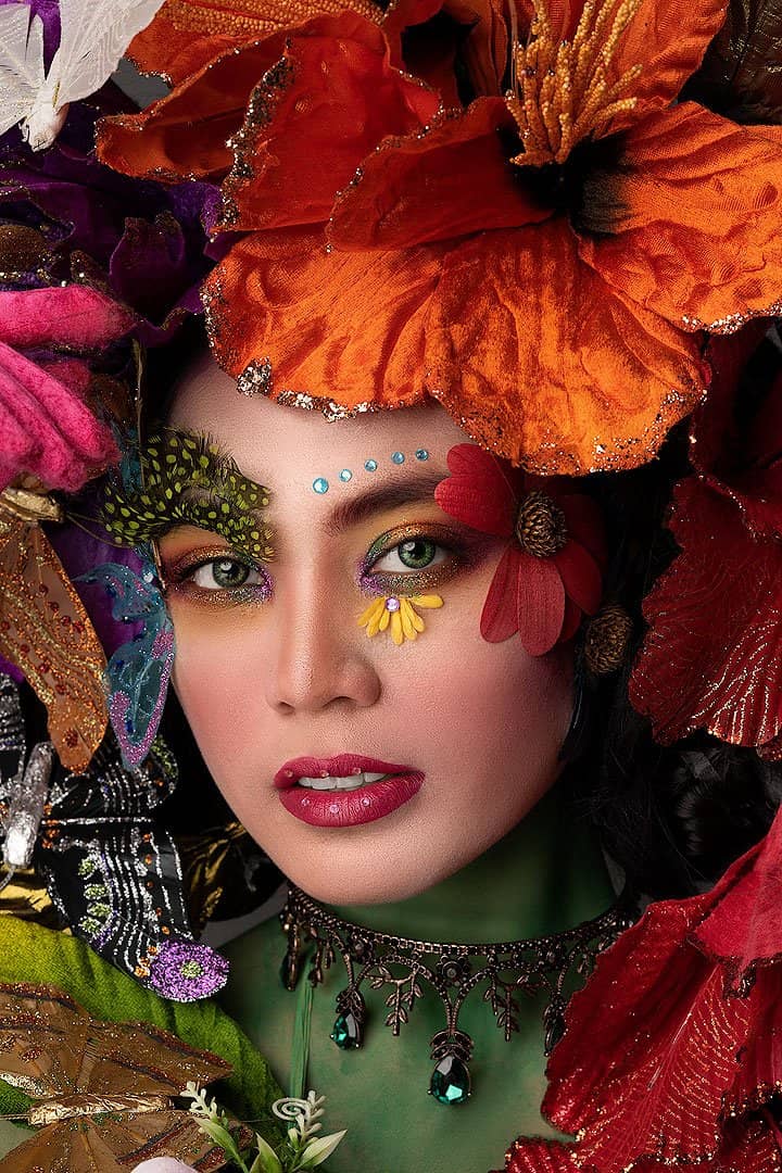 Beauty close-up with sculptural floral headpiece and bold make-up