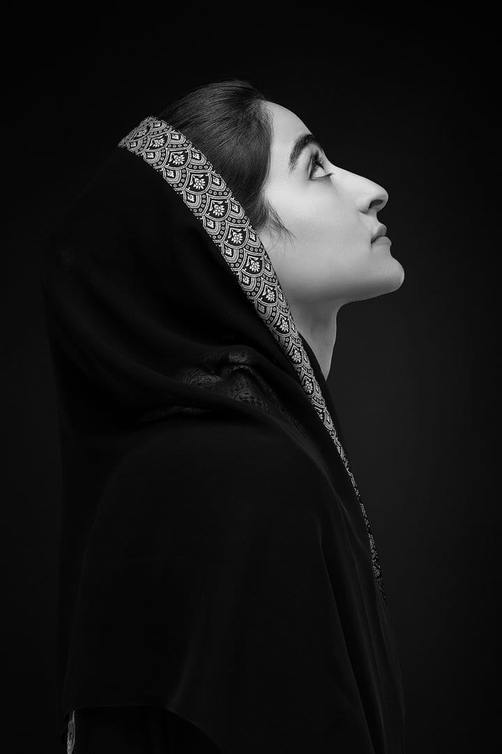 Black-and-white profile of a woman in a jewelled hood