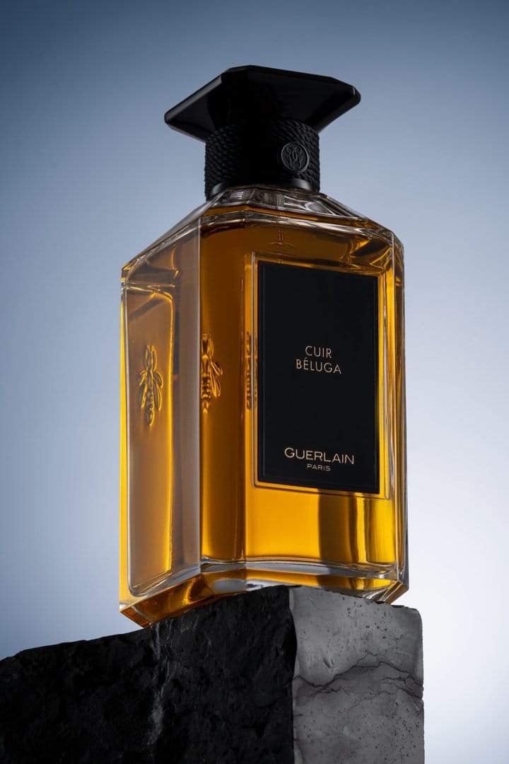 Amber perfume bottle angled on black stone