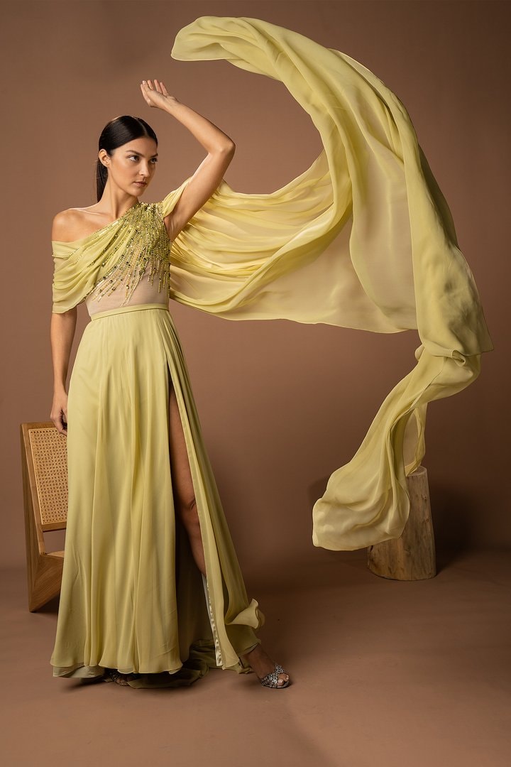 Model in a chartreuse gown with fabric thrown mid-air