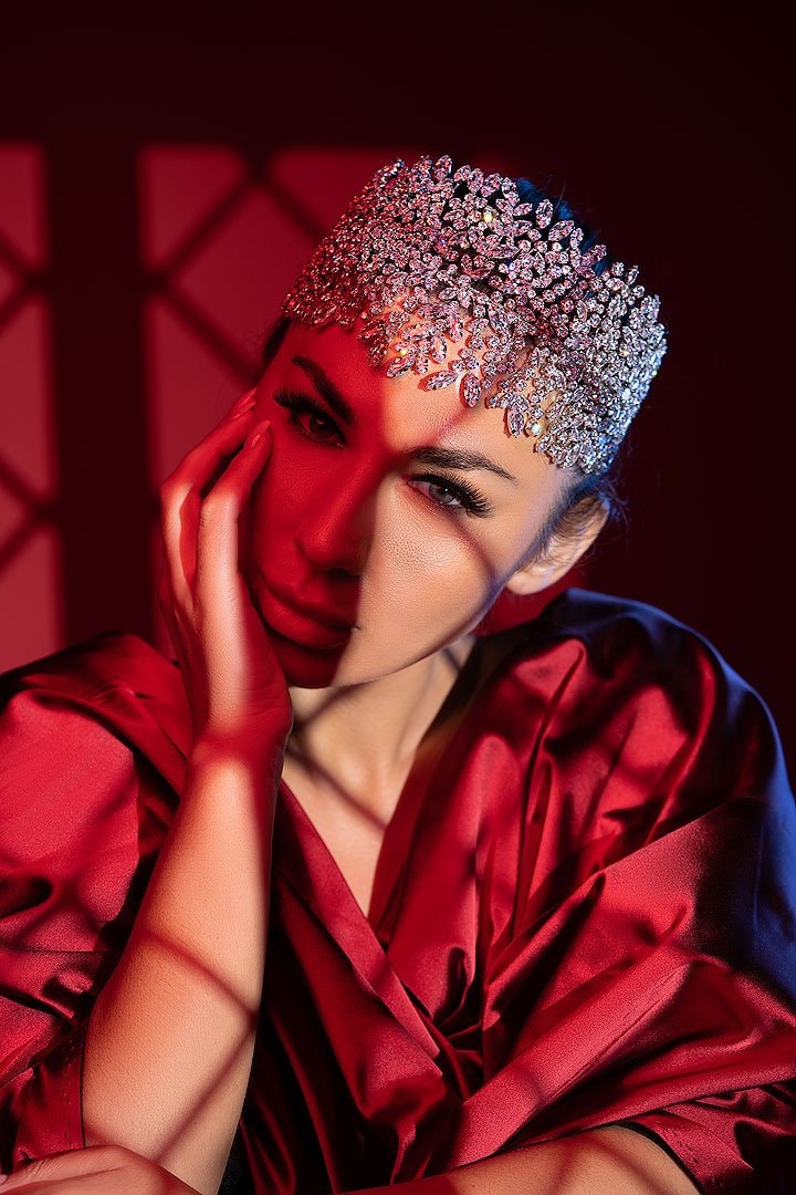 Model in a crystal headpiece lit in deep red