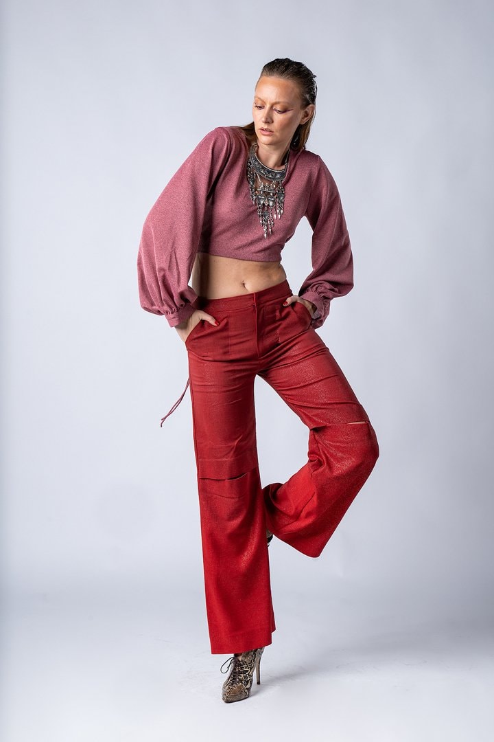 Model in a pink top and red trousers on white