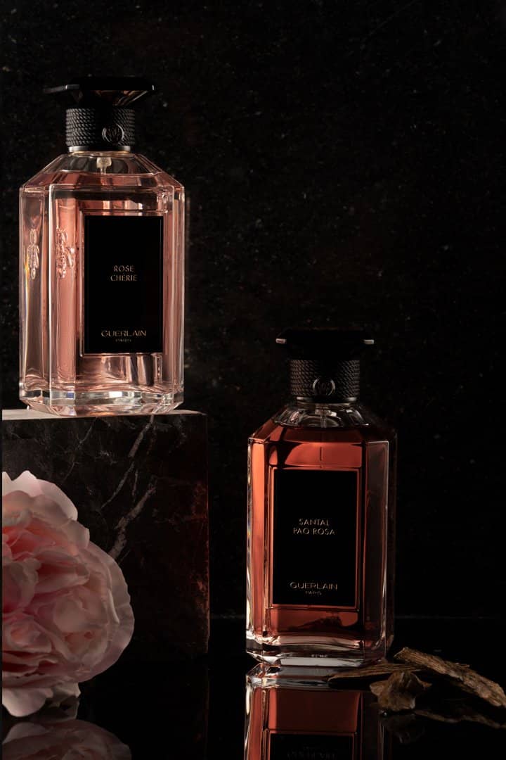 Perfume bottle on a dark surface ringed with amber light