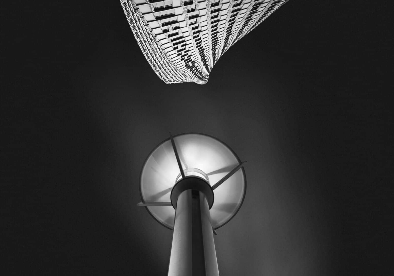 Black-and-white architectural abstract of a curved tower