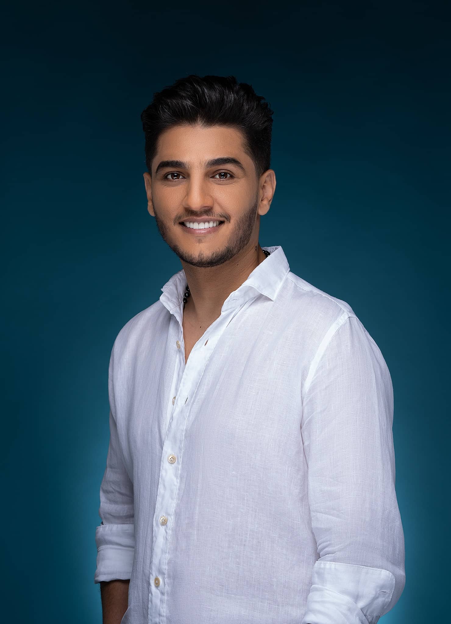 Mohammad Assaf photographed in the studio against a teal backdrop